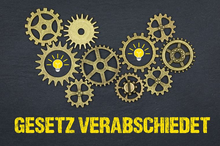 Foto: Zahnräder über Schriftzug GESETZ VERABSCHIEDET